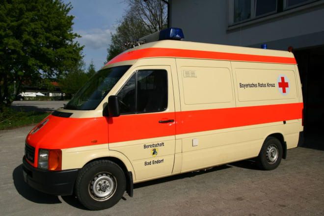 Foto: Bei einer Helferübung zum Thema Brandanschlag tragen zwei DRK-Einsatzkräfte eine Frau aus der Gefahrensituation. Sie stützen vor allem den Kopf der Frau.